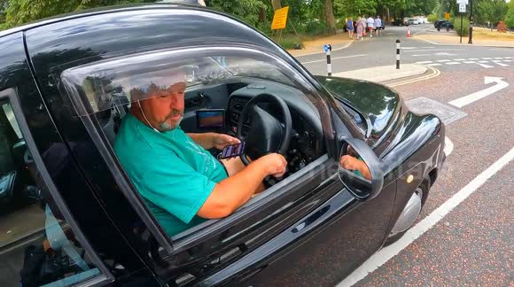 London taxi driver threatens to send cyclist to 'the dentist' after being caught using phone