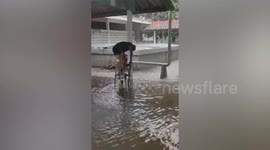 Soldier uses plastic chairs as stepping stones to avoid flash flood