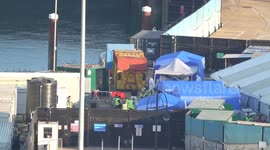 Personnel in protective clothing meet migrants in Dover, UK