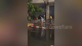 Pedestrian electrocuted by exposed cables on pavement during storm in Bangkok