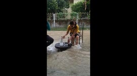 Family pitch up table and chairs to drink beer in surging flash flood