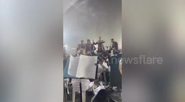 Marching band plays on through powerful storm at colleagues' retirement party