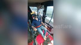 Construction worker wears helmet while operating excavator for safety