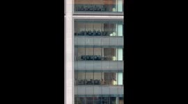 Businessman kung-fu kicking his way across meeting room delights workers in building opposite