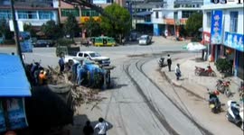 Sugarcanes fall down from an overturned farm vehicle crushing two passengers, police and the public rescue them together