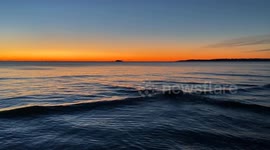 Early morning light peaking over the ocean at Nahant Bay off of Massachusetts