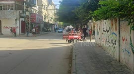 Palestinians parade through Gaza streets on Israeli military vehicle following rocket attacks