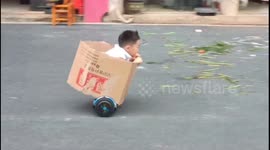 Chinese boy wows pedestrian by cruising streets on cardboard-encased hoverboard
