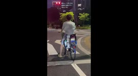 Toddler amusingly sits on back of bike under his father's t-shirt