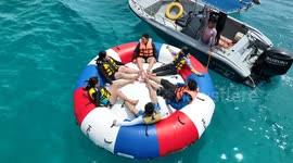 Five beachgoers flung from inflatable ride... but one holds on