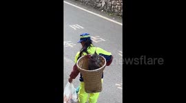 Heartwarming moment street cleaner carries cat to work for companionship