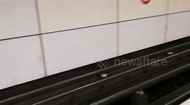 Heavy rain hits Mile End Station so much that rubbish starts to float on the water under the tracks