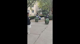 Dinosaur Suit Wearing Duo Startles Child on Campus in China