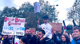 London Palestine March 21 October 2023 Young Kid holds a Home Made Rocket in protest at the killings of kids as his dad carries him