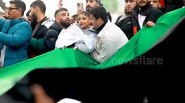 Tiny Palestinian Kid Gets lifted in air shaking a huge flag with other supporters at Trafalgar Square at the London Palestine 21st 2023 October March