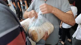 Gazans queue in front of a bakery trying to get some bread