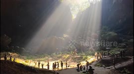Chinese people play volleyball in Tyndall-illuminated sinkhole