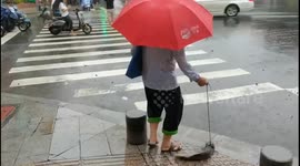 Bizarre moment elderly woman takes fish for stroll on Chinese road
