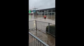 Cyclist Attempts to Ride Through Flooded Parking Lot