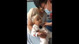 Cheeky toddler winks at doctor during checkup