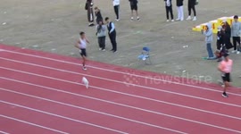 Cat runs onto track during race at university in China