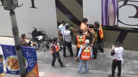 A strange incident in Bangkok city, a large man with no shirt was having some problem on the street.