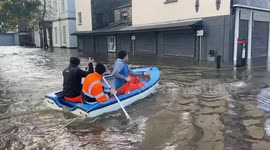 Three men paddle boat through Newry after flooding in UK