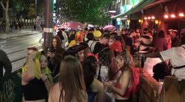 Thousands of Halloween revellers shelter from the rain which fails to dampen spirits on Broad Street in Birmingham on Tuesday night