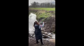 'Absolute chaos' as woman dangles on rope swing over muddy stream