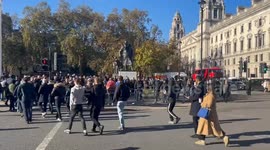 People gather around the Churchill statue in Parliament Square after Armistice Day commemorations