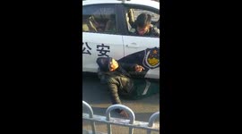 Man refuses to move from under police car
