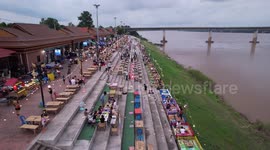 Residents eat food on the banks of river in northeast Thailand