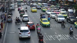 Crazy Bangkok traffic a car does an illegal U-turn on a very busy street almost causing an accident.