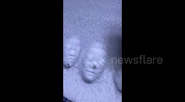 Chinese children playfully imprint 3D faces on snow-covered car