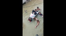 Mother and infant ferried on old fridge across heavy flood in the Philippines