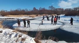 Nature's carousel! Locals ride circular chunk of ice floating in river