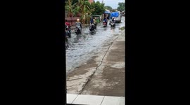 Floods create 'river of rubbish' along road in Indonesia