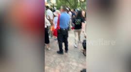 Black cat yawns and sleeps amid concert noise at park