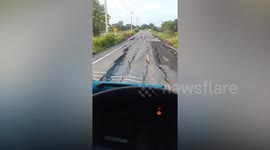 Driver carefully negotiates cracked road in Thailand