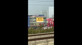 Boyfriend stands on building roof to wave goodbye to lover on train