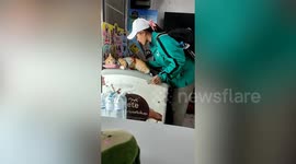 Ginger cat sleeps on top of ice cream freezer on hot day