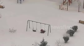 Persistent child swings through cyclone Vanya's snowy playground