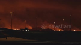 The new volcano eruption in Iceland. Cars passing on the main road with the lava in the background.