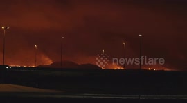 The new volcano eruption in Iceland. Cars passing on the main road with the lava in the background.
