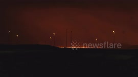 The new volcano eruption in Iceland. Cars passing on the main road with the lava in the background.