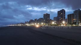 Tratores fazem limpeza na areia da praia na cidade de Praia Grande, Brasil