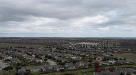 A hyper-lapse set over a suburban neighborhood.  There is an overcast with moving clouds