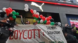 Staff member peels off 'boycott' stickers at Puma store in Canarby Street after being targeted by pro-Palestinian protest