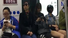Woman uses strange black facial mask on underground train