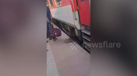 Indian mother shields children as speeding train moves past them on tracks